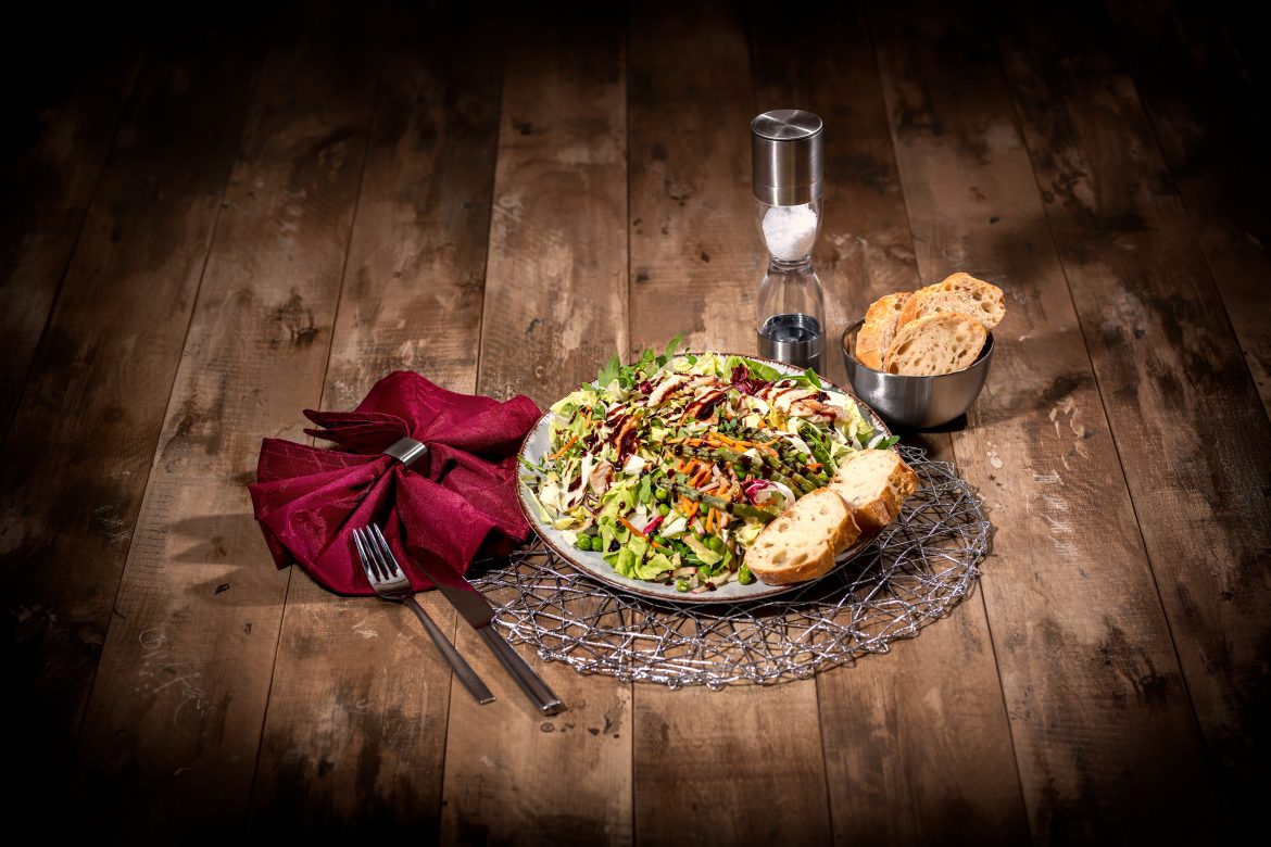 Salat mit Baguett, Besteck, Serviette und Salzmühle